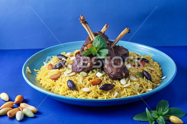 طبق من أرز الكبسة مع قطع اللحم المزين باللوز والزبيب، ولائم وأطباق عربية تقليدية شعبية، وصفات الطعام الشهية، المأكولات والوجبات الشرقية المشهورة، مطابخ ومطاعم المملكة العربية السعودية، خلفية زرقاء