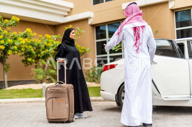 A Saudi Arabian Gulf man stops his car in front of the hotel, opens the car door for a veiled Saudi Arabian Gulf woman, carrying a travel bag in her hand, passenger delivery service, comfort and safety