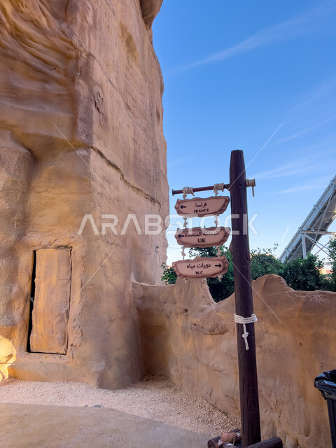 مساعدة وتوجيه السياح، لافتة ارشادية للاشارة الى اماكن في بوليفارد وورلد في المملكة العربية، اماكن ترفيهية سياحية في السعودية،  جذب واستقطاب السياح من كافة أنحاء العالم، الفن الهندسي المعماري للمنشآت الطينية المبنية على الطراز القديم 