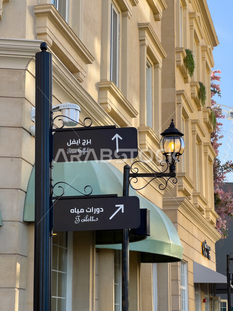 لافتة ارشاردية للإشارة الى مدخل برج ايفل ودورات المياه في بوليفارد وورد في الرياض، مساعدة وتوجيه السياح، الاستمتاع بالتجارب الممتعة في أبرز المناطق الترفيهية بالمملكة العربية السعودية، الأنشطة والفعاليات في أماكن السياحة، المباني على الطراز الحديث  