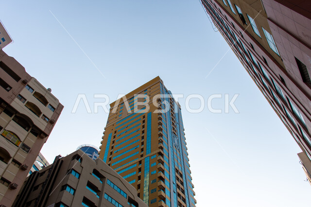 مفهوم الهندسة المعمارية والانشاءات، صورة من الاسفل لمجمع سكني  في مدينة الشارقة، أبنية ومجمعات سكنية حديثة في الامارات العربية المتحدة، الفن الهندسي للمباني على الطراز الحديث، طوابق معيشية بتصاميم وديكورات متطورة