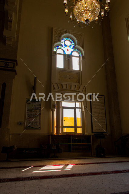 التصاميم والديكورات الداخلية المميزة للمساجد على الطراز الاسلامي الحديث، صورة من الداخل لمسجد في مدينة الشارقة، الاجواء الدينية الروحانية، أماكن إسلامية مقدسة في الامارات العربية المتحدة، العبادة والتقرب الى الله، انعكاس أشعة الشمس عبر النافذة