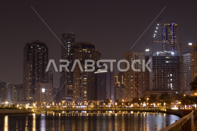 كورنيش بحيرة الخان في مدينة الشارقة بالامارات العربية المتحدة، الفن الهندسي المعماري للأبراج وناطحات السحاب المضيئة ليلا المطلة على الخليج العربي، اطلالة على وجهة المجاز البحرية، المعالم والأماكن السياحية المشهورة