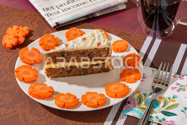 A piece of cake filled with white cream on a plate decorated with fresh carrot slices and a cup of coffee to sweeten the day, delicious cold desserts, sugars and high-calorie foods, a delicious healthy snack between meals