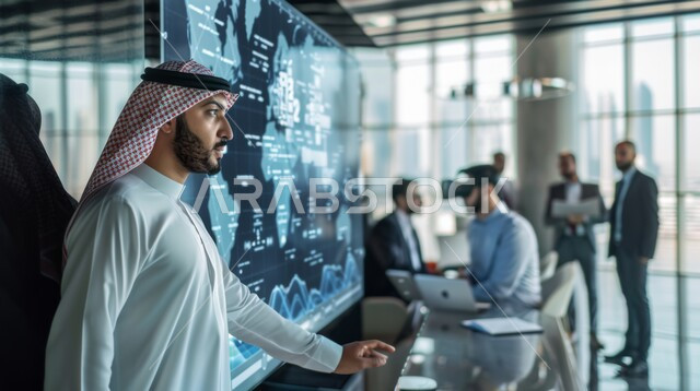 مناقشة وتنظيم الأعمال، صورة مقربة لموظف عربي خليجي سعودي يرتدي الزي التقليدي يقوم بشرح و تحليل البيانات الإحصائية في اجتماع عمل، استخدام التقنيات الحديثة في إنجاز المهام