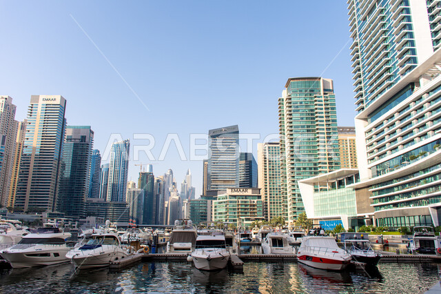 القوارب الفاخرة على مرسى اليخوت في مارينا دبي، الفن الهندسي المعماري على الطراز الحديث، وسائل النقل البحري المتميزة في منطقة نخلة الجميرا، أماكن ومعالم سياحية مشهورة في الإمارات العربية المتحدة