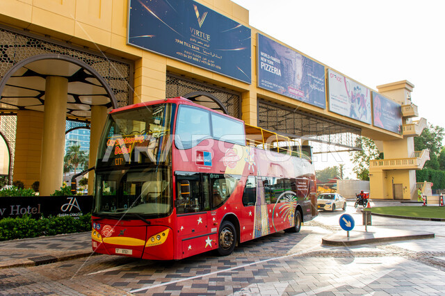Tourist bus in Jumeirah Beach Residence area in Dubai, ease and flexibility of transportation, advertising poster to promote leisure trips in the summer season, modern architectural art of buildings in the United Arab Emirates