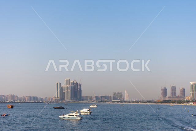 مفهوم الفرح والترفيه, يخوت فاخرة راسية قبالة شاطئ جميرا بيتش ريزيدنس بمدينة دبي بالإمارات العربية المتحدة، السياحة في الإمارات، نشاطات ترفيهية  في موسم الصيف.