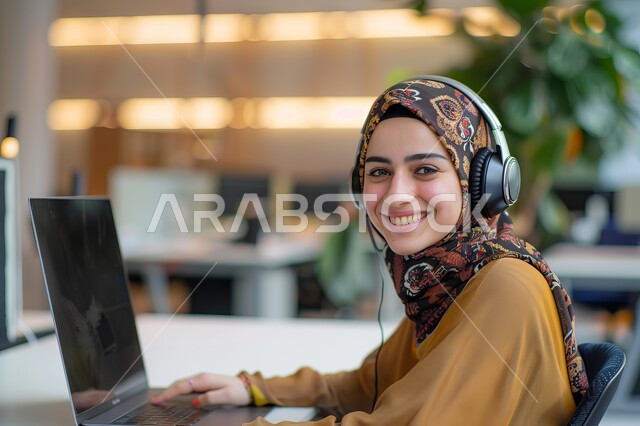  التوظيف في مجال خدمة العملاء والرد على الاسئلة والاستفسارات، الجلوس وراء المكتب وتنفيذ الأعمال على جهاز الحاسوب, شابة عربية خليجية سعودية محجبة ترتدي زي الكاجوال وتنظر للكاميرا بإيماءات السرور, مهن ووظائف نسائية سعودية, تمكين عمل المرأة في المجتمع السعودي