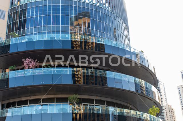 Reflective glass floors of a skyscraper in Dubai Marina, cutting-edge architecture of commercial and residential buildings and towers in Jumeirah Beach, luxury buildings and resorts in the UAE