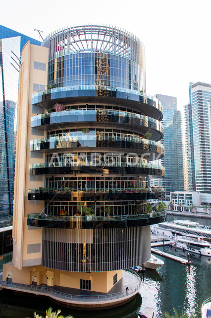 ناطحة سحاب من الزجاج ذات تصميم دائري مميز في مرسى دبي، الفن الهندسي المعماري المتطور للمنشآت التجارية والسكنية والأبراج في شاطئ جميرة، المباني والمنتجعات الفاخرة في الإمارات العربية المتحدة