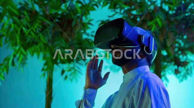 النظر إلى شيء ما في العالم الخيالي بتعابير الاندماج، التفاعل مع الواقع الافتراضي, العلوم والتكنولوجيا الحديثة والمتطورة, صورة مقربة لرجل عربي خليجي سعودي يرتدي الثوب التقليدي  يضع نظارة الفي آر ثلاثية الأبعاد
