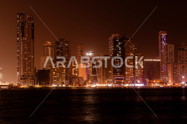 اطلالة على الوجهة البحرية، كورنيش بحيرة خالد في مدينة الشارقة بالامارات العربية المتحدة، الفن الهندسي المعماري للأبراج وناطحات السحاب المضيئة ليلا المطلة على الخليج العربي، المعالم السياحية المشهورة، اماكن جذب واستقطاب السياح