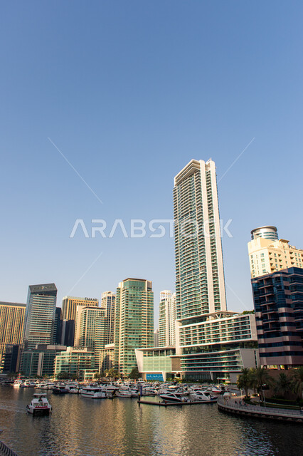 الواجهة البحرية للخليج العربي في وضح النهار, مرسى إمارة دبي في الإمارات العربية المتحدة, أماكن ومعالم ساحلية سياحية مشهورة في نخلة الجميرا, تطور الفن الهندسي المعماري للأبراج وناطحات السحاب المطلة على مرفأ اليخوت، القوارب الفاخرة لحديثة