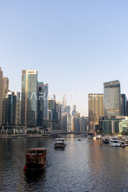 الواجهة البحرية للخليج العربي في وضح النهار, قوارب فاخرة حديثة، مرسى إمارة دبي في الإمارات العربية المتحدة, أماكن ومعالم ساحلية سياحية مشهورة, تطور الفن الهندسي المعماري للأبراج وناطحات السحاب المطلة على مرفأ اليخوت