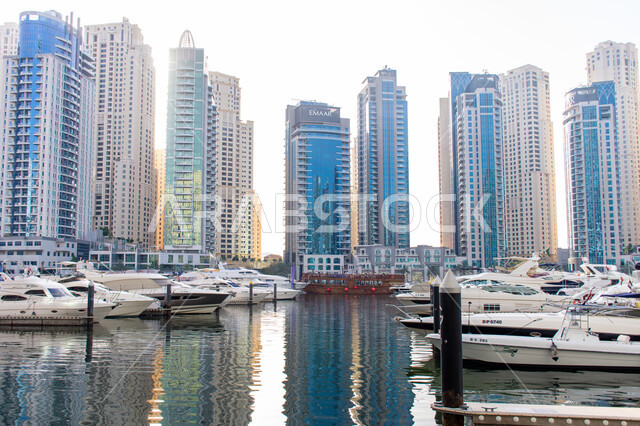 Famous places and landmarks in the United Arab Emirates, modern architecture, excellent marine transportation in the Palm Jumeirah area, luxury boats on the yacht marina in Dubai Marina, recreational activities in the summer season.
