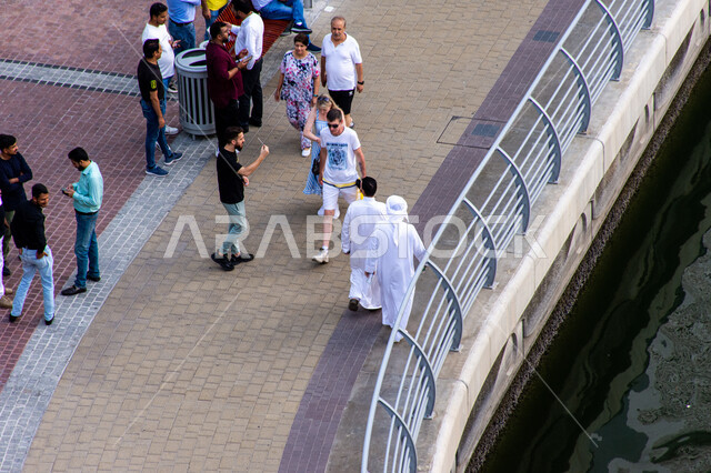  وجهه عائلية للقيام بالأنشطة والفعاليات الممتعة، ممرات عامة للتجول والتنزه في الهواء الطلق، مجموعة من الناس يتجولون في ممشى مارينا دبي، مناطق جذب واستقطاب السياح، اماكن ترفيهيه سياحية في دولة الامارات العربية المتحدة