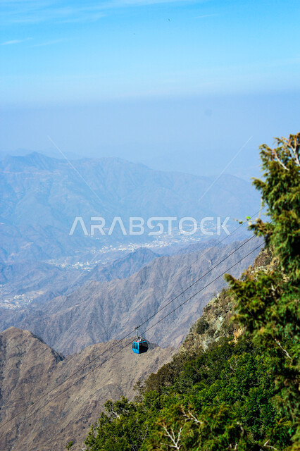  التضاريس والبيئة الجبلية لمنطقة أبها في عسير، الطبيعة الخضراء والمنتزهات والحدائق الجميلة، سلاسل الجبال الصخرية والقمم العالية، الأشجار والنباتات المغطية لسفوح الجبل، أماكن طبيعية للمغامرات ورحلات السفاري والاستمتاع، خلفية السماء بالسحب البيضاء