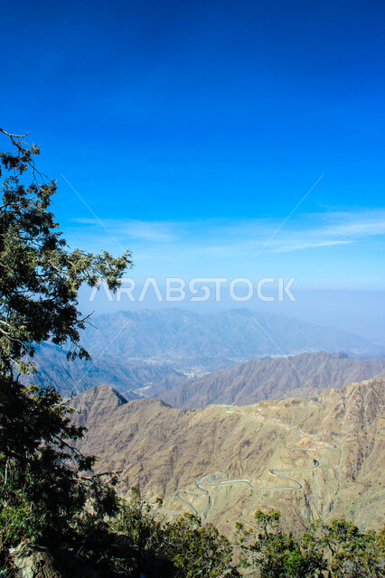  التضاريس والبيئة الجبلية لمنطقة أبها في عسير، الطبيعة الخضراء والمنتزهات والحدائق الجميلة، سلاسل الجبال الصخرية والقمم العالية، الأشجار والنباتات المغطية لسفوح الجبل، أماكن طبيعية للمغامرات ورحلات السفاري والاستمتاع، خلفية السماء بالسحب البيضاء