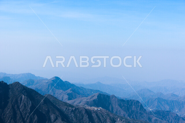  التضاريس والبيئة الجبلية لمنطقة أبها في عسير، الطبيعة الخضراء والمنتزهات والحدائق الجميلة، سلاسل الجبال الصخرية والقمم العالية، الأشجار والنباتات المغطية لسفوح الجبل، أماكن طبيعية للمغامرات ورحلات السفاري والاستمتاع، خلفية السماء بالسحب البيضاء