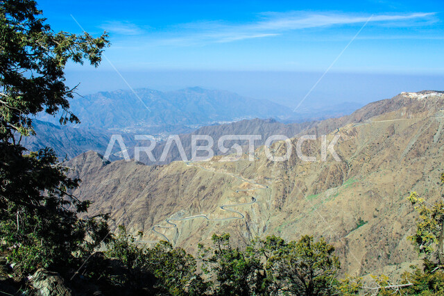  التضاريس والبيئة الجبلية لمنطقة أبها في عسير، الطبيعة الخضراء والمنتزهات والحدائق الجميلة، سلاسل الجبال الصخرية والقمم العالية، الأشجار والنباتات المغطية لسفوح الجبل، أماكن طبيعية للمغامرات ورحلات السفاري والاستمتاع، خلفية السماء بالسحب البيضاء