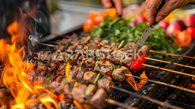مطاعم ومطابخ المملكة العربية السعودية، تصاعد النيران من منقل الشواء، صورة مقربة ليد رجل عربي سعودي خليجي يمسك اسياخ من قطع من الدجاج والخضراوات الشهية المشوية على الفحم، أصناف الأطعمة الشرقية، وجبات غذائية غنية بالبروتين
