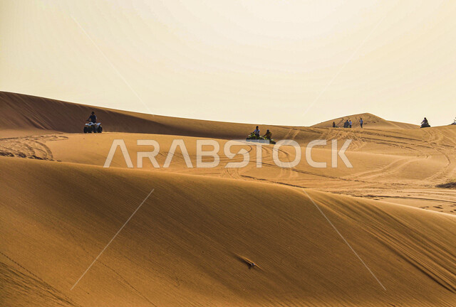 البيئة الطبيعية الخليجية الجافة، تشكل الكثبان والقمم الرملية في الصحاري, المساحات الصحراوية الشاسعة الممتدة على طول الأفق, مشهد لتداخل ألوان رمال الصحراء الذهبية اللامعة مع خلفية السماء الزرقاء الصافية