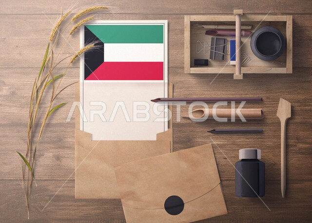 ورقة بيضاء تحمل العلم الكويتي، تصميم هوية تجارية تتعلق بدولة الكويت، صورة من الاعلى لمجموعة من الادوات المكتبية والاكسسوارات على سطح خشبي، مفهوم رسالة الاحتفال