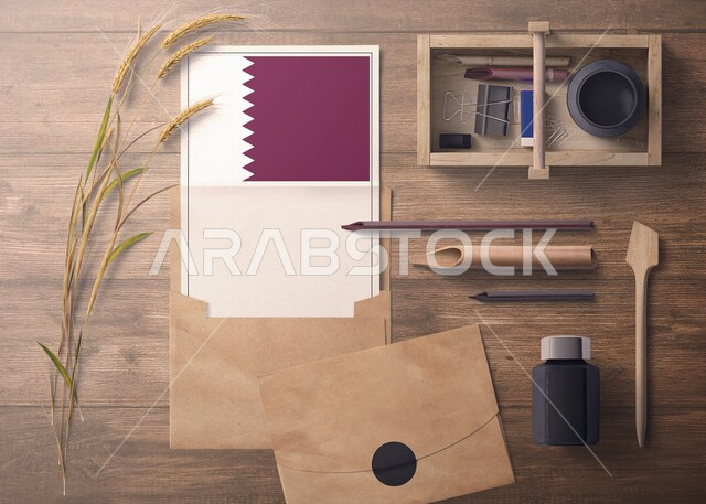ورقة بيضاء تحمل العلم القطري، تصميم هوية تجارية تتعلق بدولة القطر، صورة من الاعلى لمجموعة من الادوات المكتبية والاكسسوارات على سطح خشبي، مفهوم رسالة الاحتفال