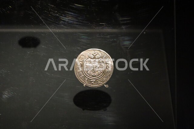 درهم ساساني معرب يعود لعهد الخليفة معاوية بن أبي سفيان معروض في متحف بينالي للفنون الإسلامية في المملكة العربية السعودية, المعالم الثقافية المشهورة في مدينة جدة، التحف الدينية الأثرية المميزة، وجهات جذب واستقطاب السياح والزوار للتعرف على تاريخ الأرض المقدسة