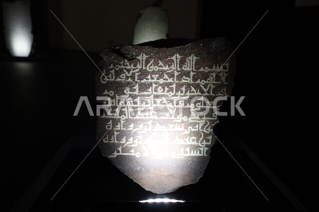 شاهدة قبر حجرية تاريخية تحتوي على آيات قرآنية، المعالم الثقافية المشهورة في مدينة جدة، متحف بينالي للفنون الإسلامية في المملكة العربية السعودية, التحف الدينية الأثرية المميزة، وجهات جذب واستقطاب السياح والزوار للتعرف على تاريخ الأرض المقدسة