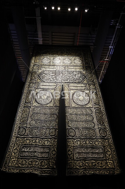 Rare historical religious manuscripts, the black silk curtain of the Kaaba door engraved with verses from the Holy Quran, a display of the Kaaba Kiswa embroidered with gold and silver threads, learning about the culture and history of the Holy Land, the Biennale Museum of Islamic Arts in Jeddah, Saudi Arabia