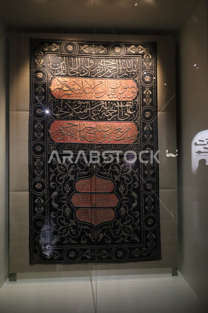 الستارة الحريرية السوداء لباب الكعبة المنقوشة بآيات من القرآن الكريم، عرض لكسوة الكعبة المطرزة بخيوط ذهبية وفضية، التعرف على ثقافة وتاريخ الأراضي المقدسة، متحف بينالي للفنون الإسلامية في جدة بالمملكة العربية السعودية, التحف والمقتنيات الدينية الأثرية المميزة
