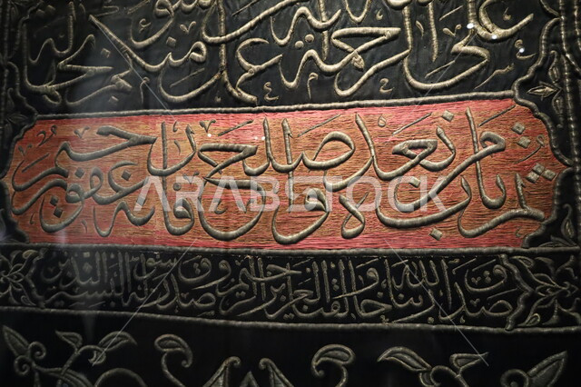 عرض لكسوة الكعبة المطرزة بخيوط ذهبية وفضية، المخطوطات الدينية الأثرية التاريخية، صورة مقربة للستارة الحريرية السوداء لباب الكعبة المنقوشة بآيات القرآن الكريم، التعرف على ثقافة وتاريخ الأرض المقدسة، متحف بينالي للفنون الإسلامية في جدة بالمملكة العربية السعودية