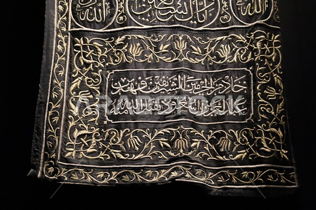 الستارة الحريرية السوداء لباب الكعبة المنقوشة بآيات من القرآن الكريم، عرض لكسوة الكعبة المطرزة بخيوط ذهبية وفضية، التعرف على ثقافة وتاريخ الأراضي المقدسة، متحف بينالي للفنون الإسلامية في جدة بالمملكة العربية السعودية, التحف والمقتنيات الدينية الأثرية المميزة