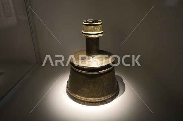  الشمعدان النحاسي المستخدم في العصور القديمة معروض في متحف بينالي للفنون الإسلامية في المملكة العربية السعودية, التحف والمقتنيات الدينية الأثرية المميزة، وجهات جذب واستقطاب السياح والزوار للتعرف على تاريخ الأرض المقدسة، المعالم الثقافية المشهورة في مدينة جدة