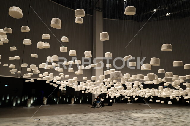 Pilgrims' Hall filled with white hats hanging from the ceiling, Biennale Museum of Islamic Arts in Jeddah, Saudi Arabia, attractions and tourist and visitor destinations to learn about the history of the Holy Land, famous cultural landmarks, distinctive religious artifacts and collectibles