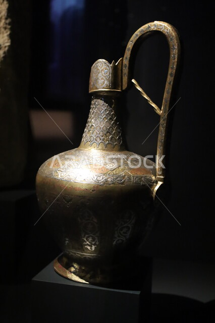 إبريق نحاسي مستخدم في العصور القديمة معروض في متحف بينالي للفنون الإسلامية في المملكة العربية السعودية, التحف والمقتنيات الدينية الأثرية المميزة، وجهات جذب واستقطاب السياح والزوار للتعرف على تاريخ الأرض المقدسة، المعالم الثقافية المشهورة في مدينة جدة
