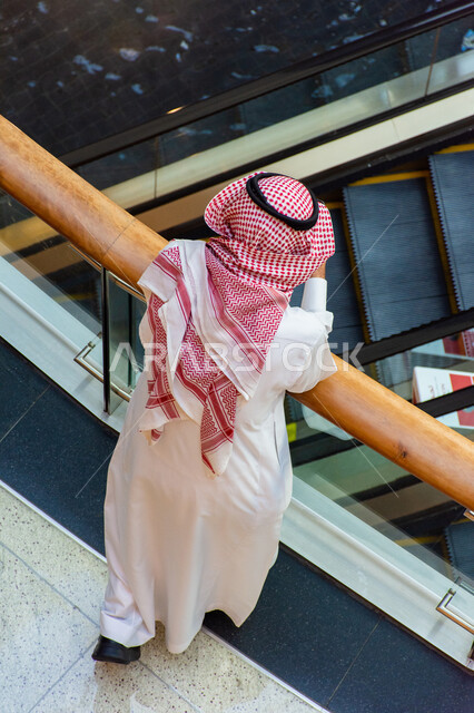 Architectural art, designs and interior decorations of malls, tourism in the United Arab Emirates, shopping malls and luxury stores, A picture from above of an Arab Gulf Emirati man wearing the gandoura and ghutra inside the Dubai Mall in the Emirate of Dubai, places of recreational family activities