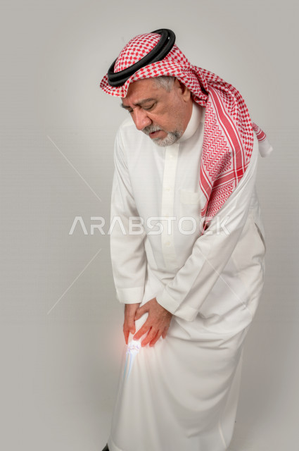 صورة مقربة لرجل عربي خليجي سعودي ، مريض يعاني من آلام الركبة و المفاصل، أمراض والتهابات العظام ، الحاجة الي التشخيص و العلاج .