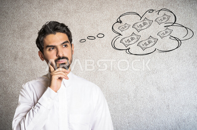 صورة مقربة لرجل عربي خليجي سعودي يضع يده على وجهه يفكر بكيفية الحصول على الأموال ، إيماءات الوجه و اليدين للتفكير بكيفية ربح المال ، ايجاد مصدر دخل مالي ، فقاعة تفكير تحتوي على رموز خاصة بالريال السعودي .