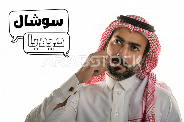 صورة مقربة لرجل عربي خليجي سعودي أمام خلفية بيضاء يضع يده على وجهه و يفكر بمواقع التواصل الاجتماعي ، ايماءات و تعابير الوجه و اليدين ، فقاعات التفكير تحتوي على كلمات سوشيال و ميديا .