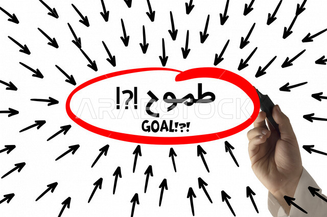 A close-up of the hand of a Saudi Arabian Gulf man doing a hand sketch of a group of arrows directed towards the word ambition surrounded by a circle, goals and future vision.