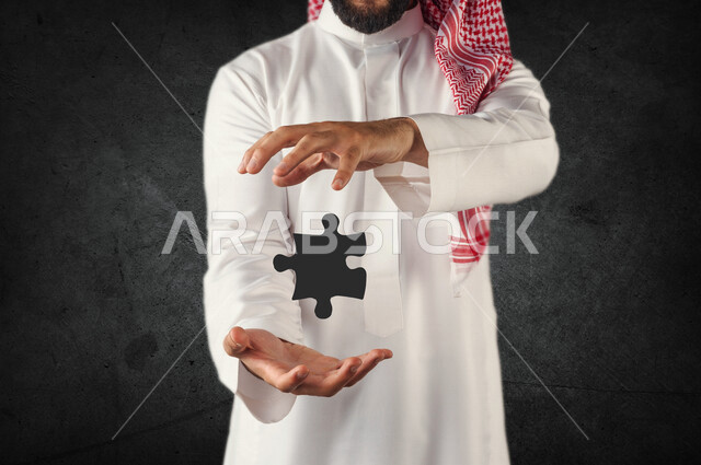 A close-up of a Saudi Arabian Gulf man with his hand in the shape of a three-dimensional puzzle, finding solutions to puzzles and solving problems.