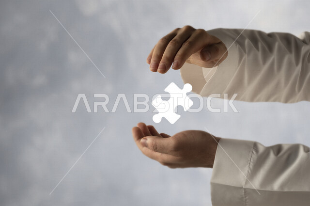 صورة مقربة لرجل عربي خليجي سعودي بيده شكل  البازل ثلاثي الأبعاد ، ايجاد حلول للألغاز و حل المشكلات .