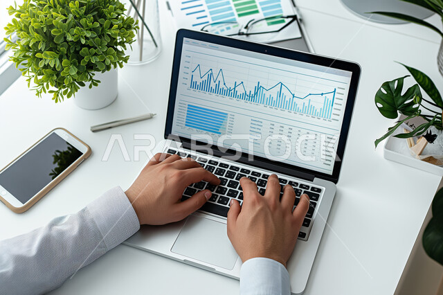 مفهوم العمل عن بعد، استخدام الاجهزة التقنية الحديثة، ادارة مهام العمل اليومية في مقر الشركة، صورة مقربة لرجل عربي خليجي سعودي يرتدي الزي التقليدي يجلس في مكتبه يعمل على جهاز الحاسوب المحمول، مهن ووظائف سعودية