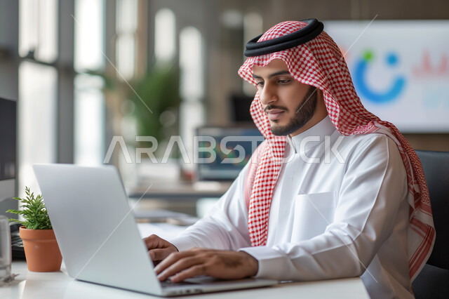 مهن ووظائف ادارية مكتبية, إنجاز المهام العمل المطلوبة ، دمج العمل مع التقنيات والتكنولوجيا، مفهوم إدارة شؤون الأعمال وتنظيمها عبر الاجهزة التقنية، رجل اعمال عربي خليجي سعودي يعمل على الحاسوب المحمول داخل المكتب