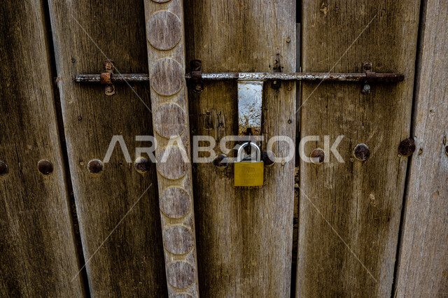 الفن الهندسي المعماري على الطراز القديم , قلعة الرملية في مدينة العين بأبو ظبي , المعالم السياحية المشهورة , الحصون والقلاع الحربية المشيدة , مناطق جذب واستقطاب السائحين في الإمارات العربية المتحدة، صورة مقربة لباب خشبي قديم