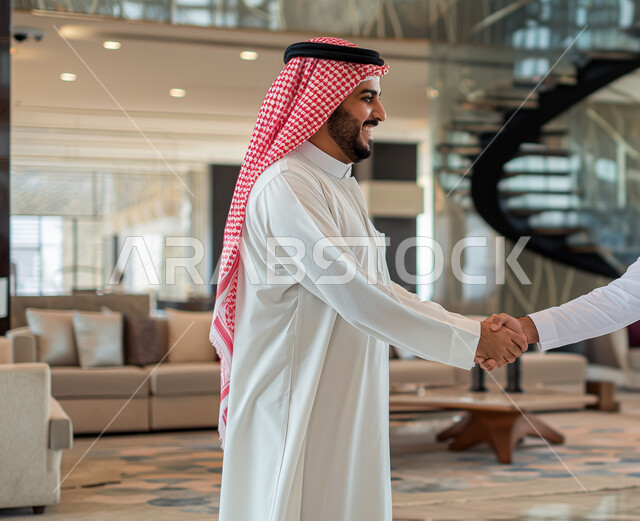 الترحيب والسلام وإلقاء التحية، الاتفاق على المشاريع التجارية، رجل عربي خليجي سعودي يرتدي الثوب والشماغ التقليدي يقوم بالمصافحة، بيئة العمل المريحة في الشركات السعودية, حوارات و مناقشات لتحقيق الاستراتيجيات والغايات