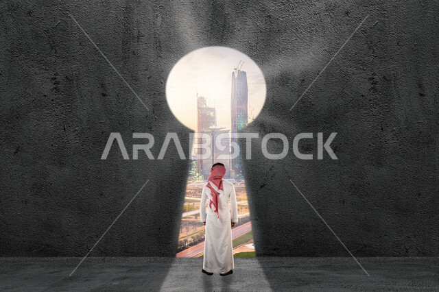 صورة من الخلف لرجل عربي خليجي سعودي يقف أمام بوابة عبور للمملكة العربية السعودية على شكل مفتاح من خلال تقنية الهولوجرام ، تأمين و حماية دخول البلاد ، تحقيق الأهداف والانجازات ، استخدام تقنية الهولوجرام ثلاثية الأبعاد .